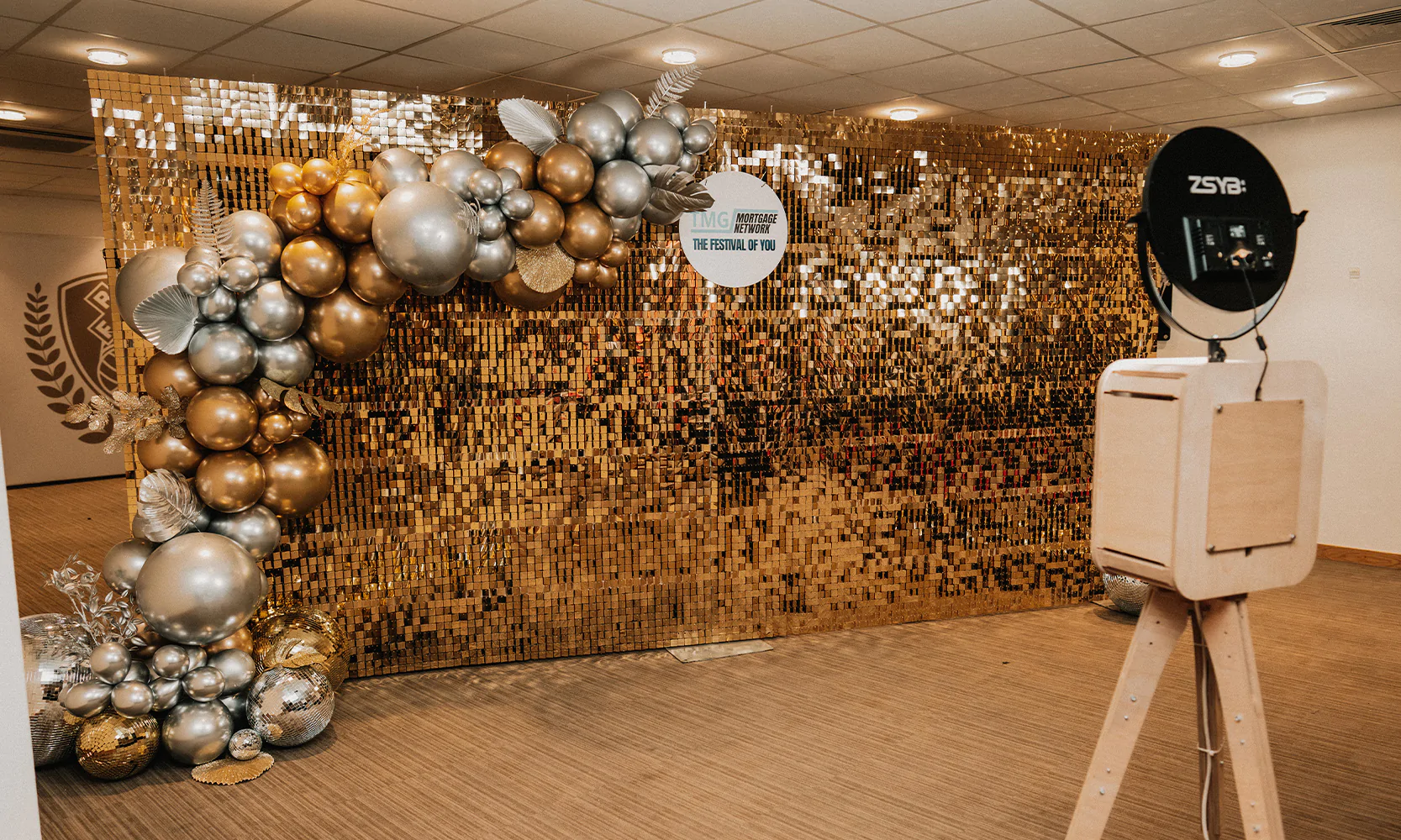 Photo booth with gold corporate branding.