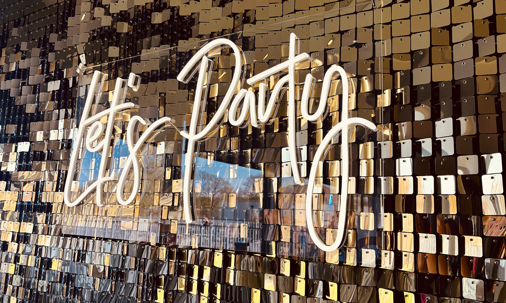 Let's Party neon sign on a gold sequin wall