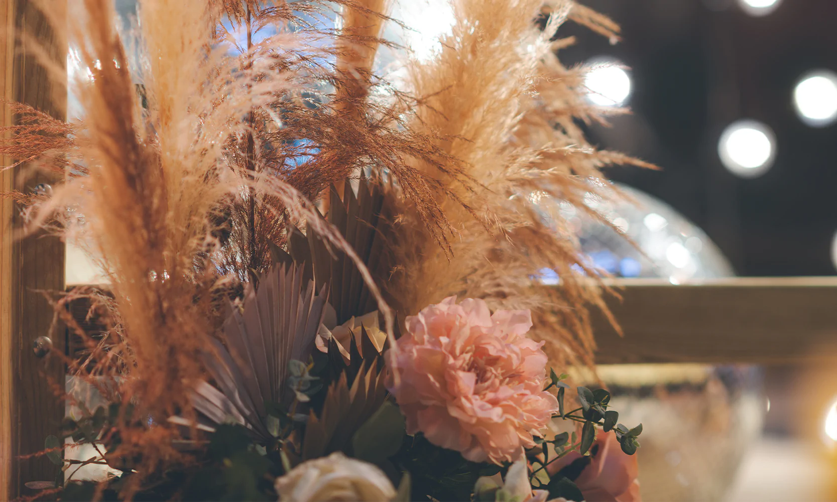 Spring event decor with pampas grass and soft floral styling creating a warm celebration atmosphere