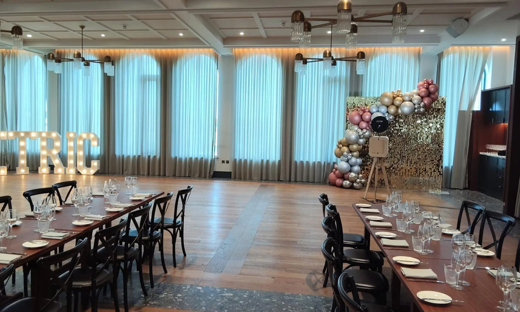 Elegant party venue setup with light-up letters, sequin wall backdrop and balloon garland