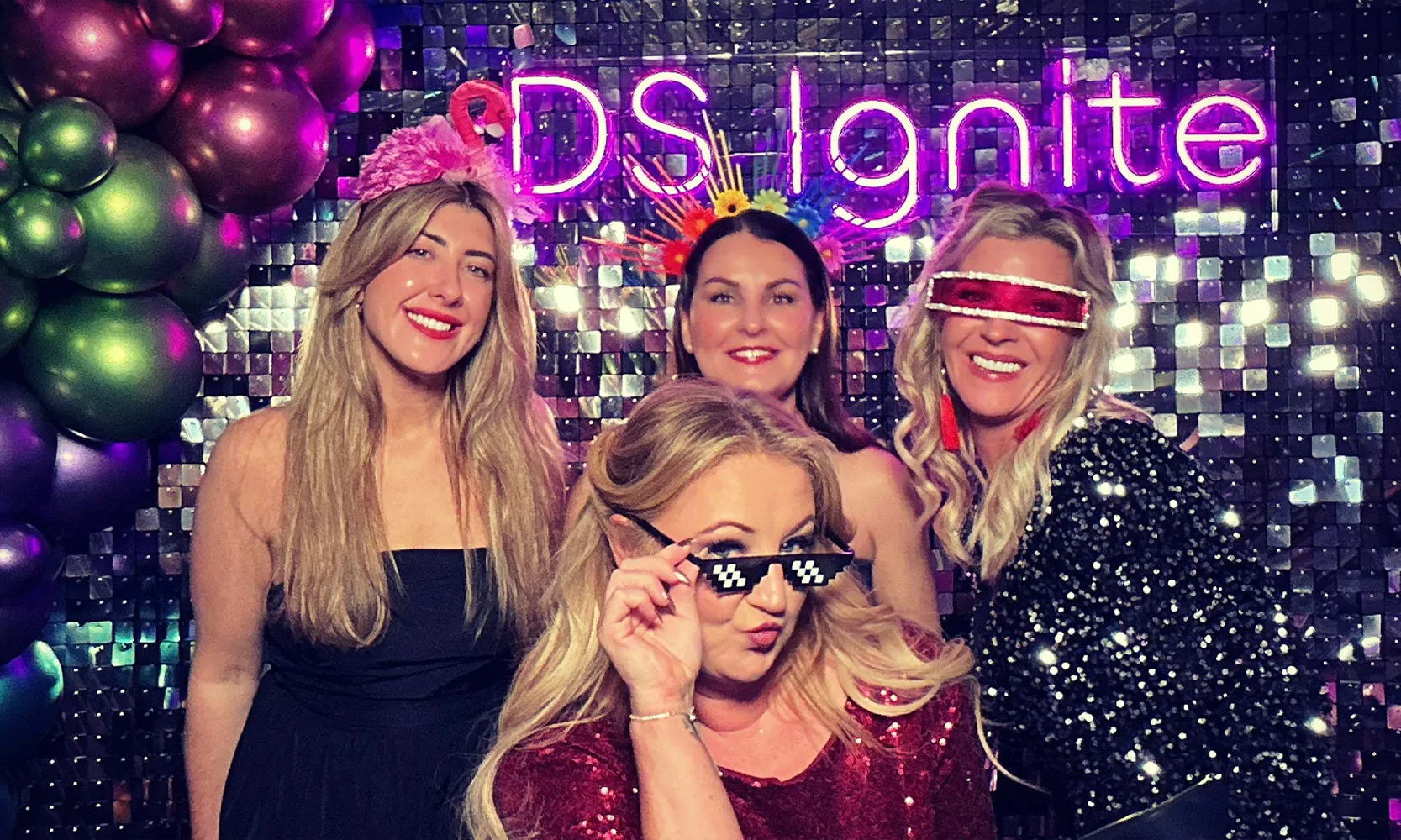 Silver sequin wall and custom neon sign at party.