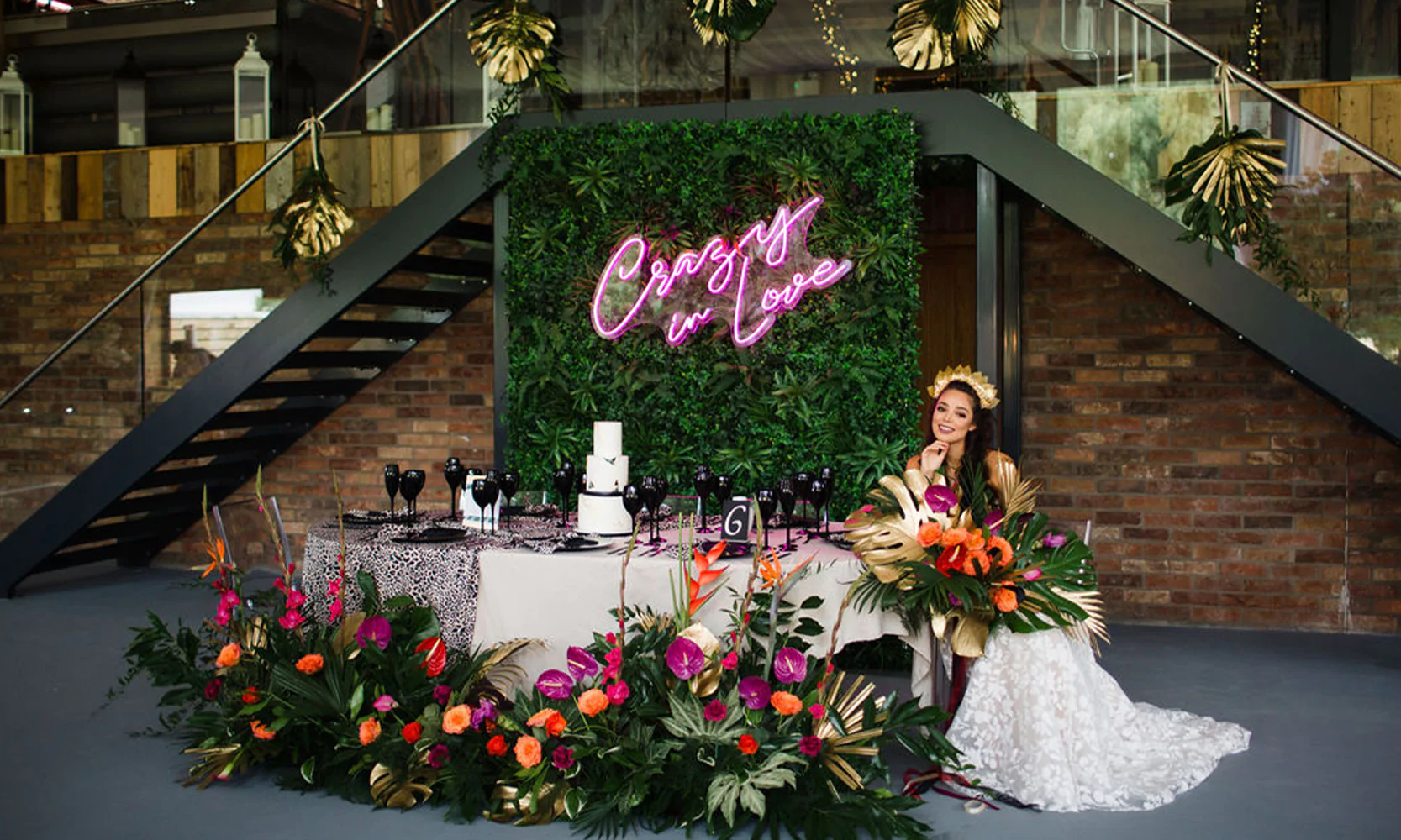 Foliage backdrop with neon sign and flower arrangements.