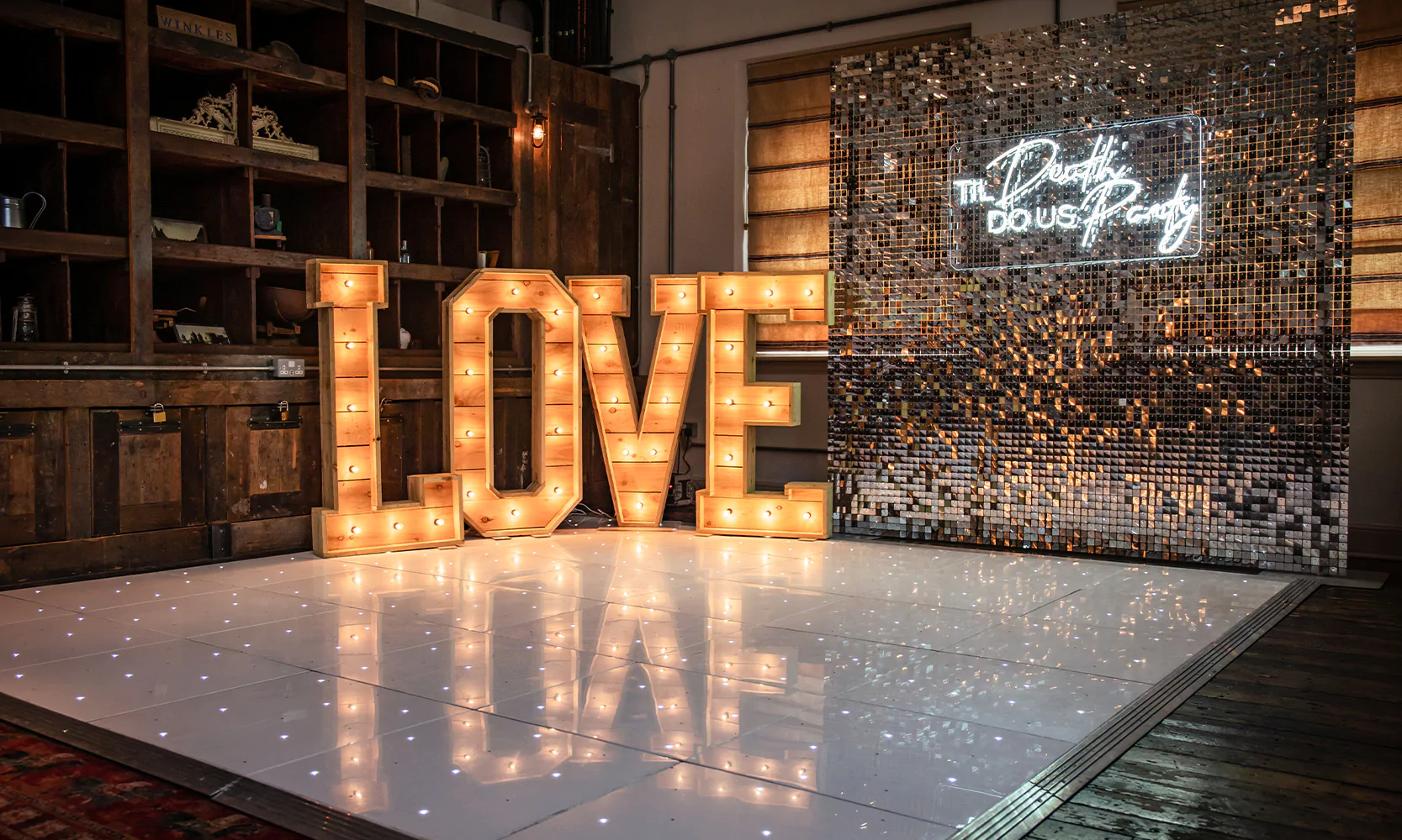 Rustic 'Love' light-up letters with dance floor, silver sequin wall and neon sign.